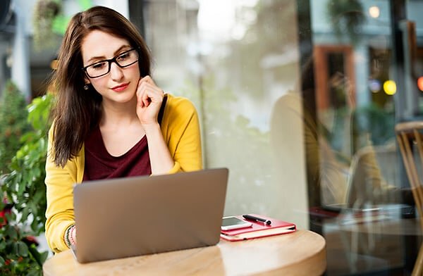 Woman sitting outside looking at laptop