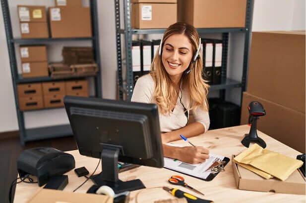Happy, smiling woman in headset, taking notes on clipboard