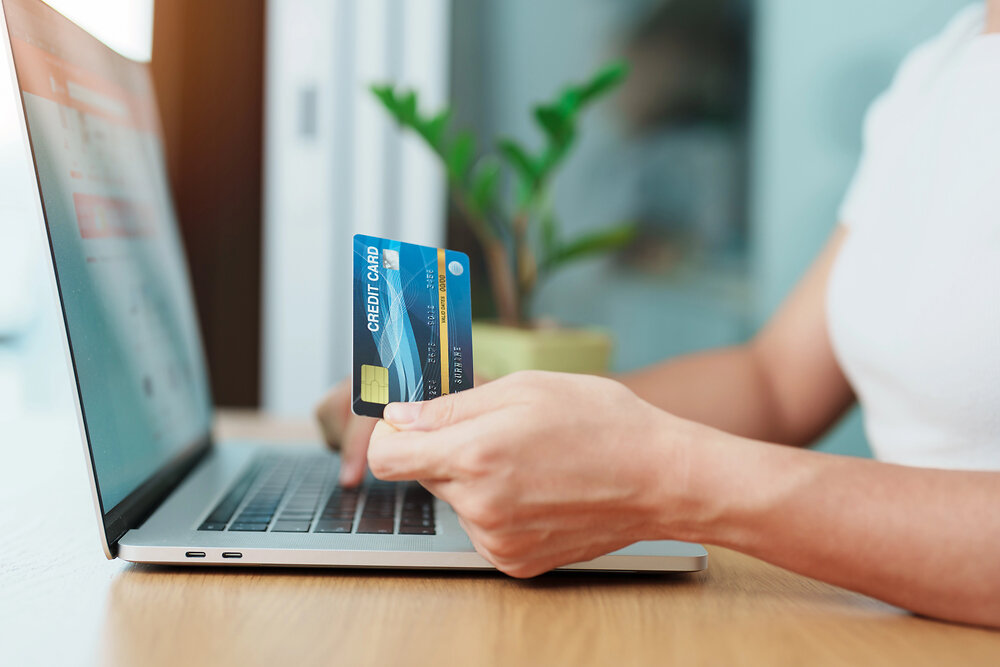 woman hand holding credit card and using laptop for online shopping while making order at home. Marketplace platform website, technology, ecommerce, digital banking and online payment concept