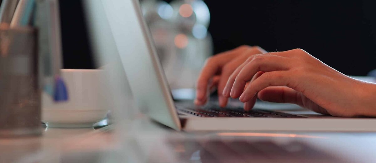 Close Up Of Hands Typing On Laptop