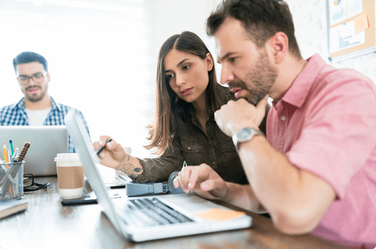 Workers at desk looking at laptop