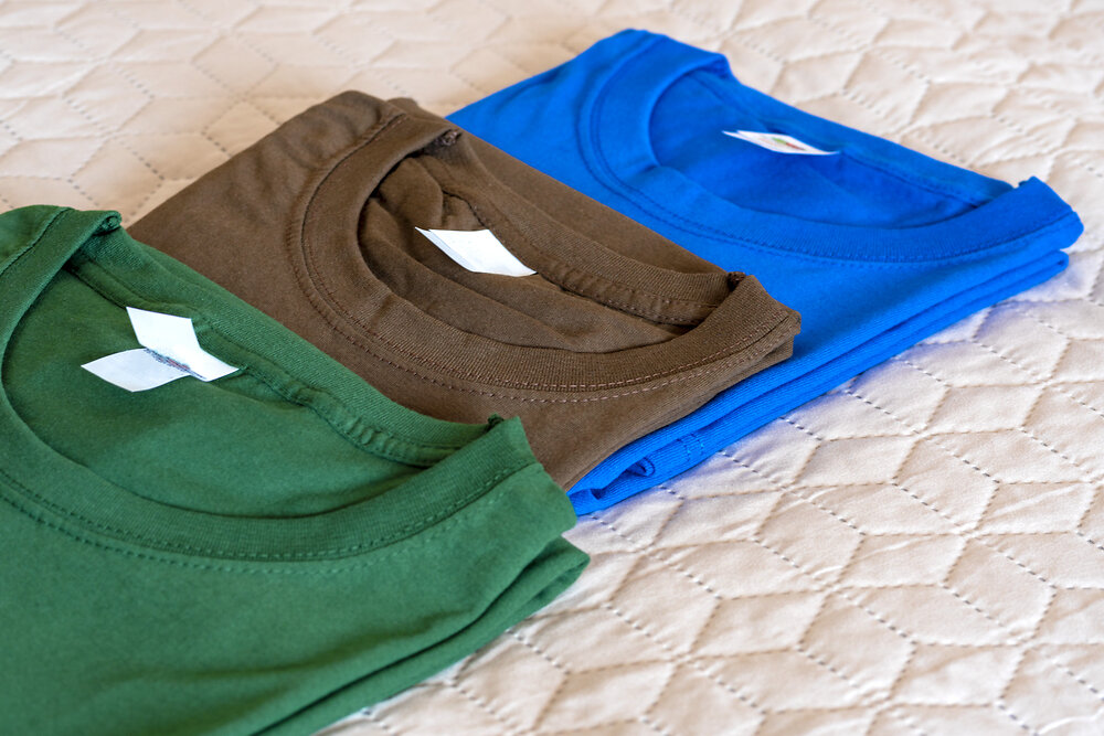 Folded t-shirts different colours. Sportswear in the store